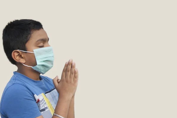 Ragazzo Che Prega Indossando Una Maschera Protettiva Contro Coronavirus — Foto Stock