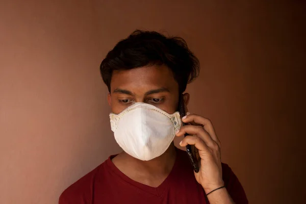 印度男孩用防污染面罩盖住脸 以防止感染Covid 并在手机上交谈 — 图库照片