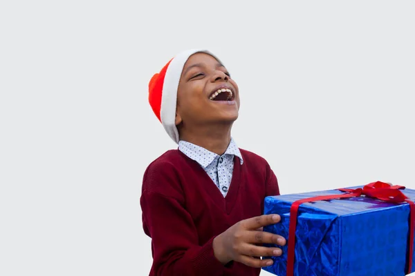 Genç çocuk Noel hediyesiyle gülümsüyor.