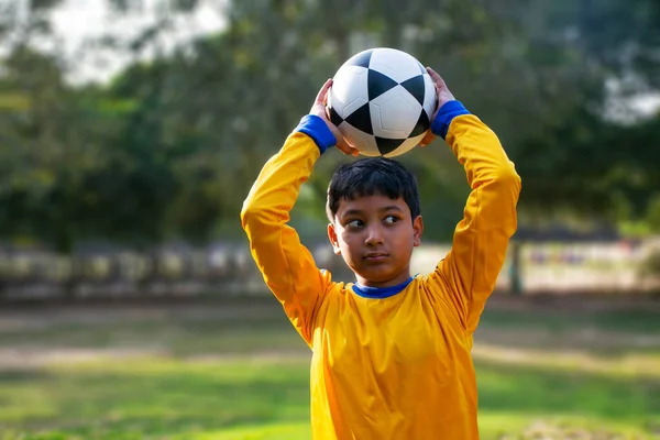一个小男孩扔足球的肖像 — 图库照片