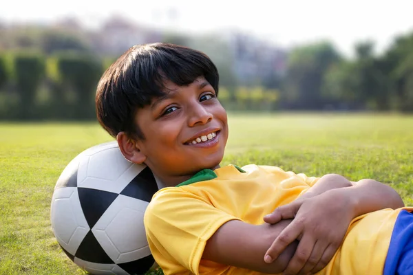 Mladý Chlapec Ležící Zemi Fotbalem — Stock fotografie