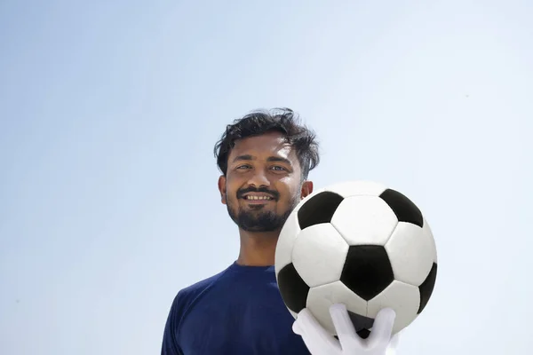 Futbol topu tutan Hintli kalecinin portresi