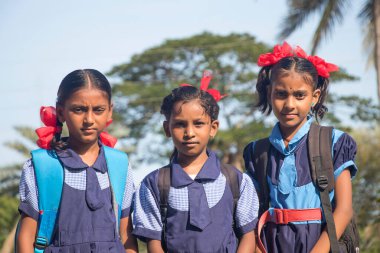 Açık havada duran, okul üniforması giyen Hintli bir kırsal okul kızı.