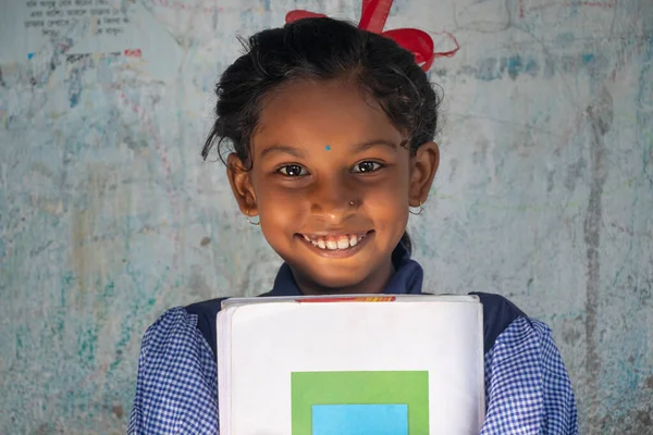 Okulda gülümseyen ve ayakta duran bir okul kızının portresi.