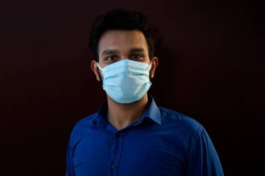 Genç adam maske takarak kendini ön plana çıkarıyor.