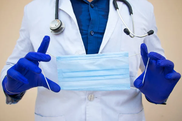 Renkli arka planda tıbbi maskesi olan bir erkek doktor.