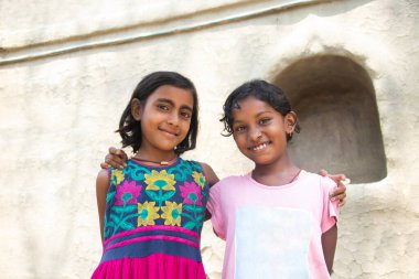 İki sevimli taşralı çocuk evde birlikte portre çekiyorlar.