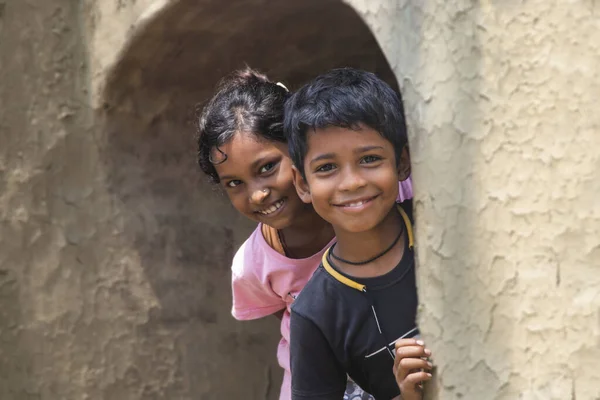 从土墙向外窥探的印度农村儿童 免版税图库照片