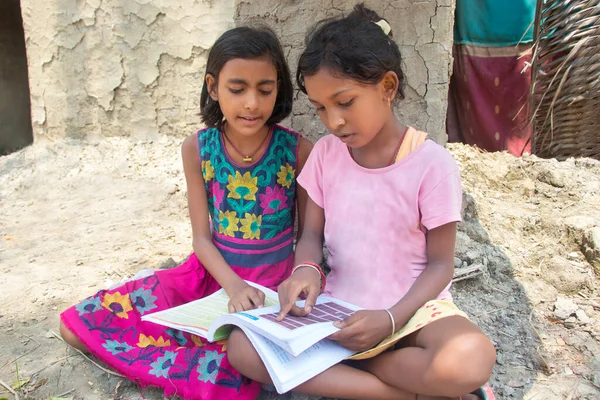 两名印度农村女孩在家看书 图库照片