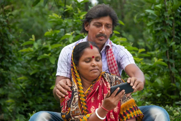 印度农村夫妇在农业领域看电影 图库图片