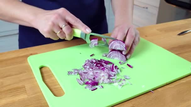 Close up woman cutting red onion. Cook quickly chopping a red onion on wooden table — Stock Video