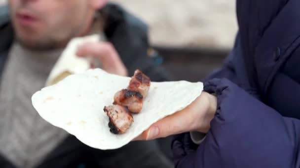 Dívka připravuje kebab z pita chleba, grilované maso a grilovací omáčka na pikniku na pláži — Stock video