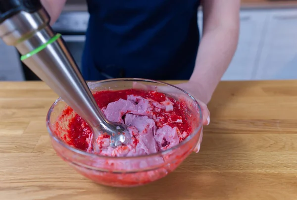 Çilek ve yoğurttan yapılan dondurma pişirme işlemi blender ile birlikte bir kasede.