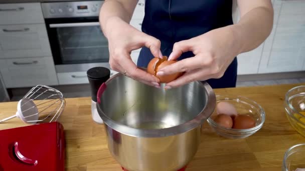 Cocinero agrietando un huevo en un tazón y separa la yema de la proteína. — Vídeos de Stock