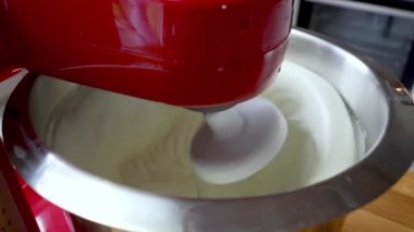 Şef, malzemeleri metal kasede elektrikli mikserle karıştırıyor. Tatlı yapmak için lezzetli krema hazırlıyorum. Ev yemeği.