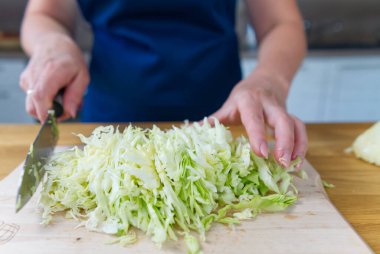 Şef sağlıklı sebze salatası yapmak için lahana dilimler..