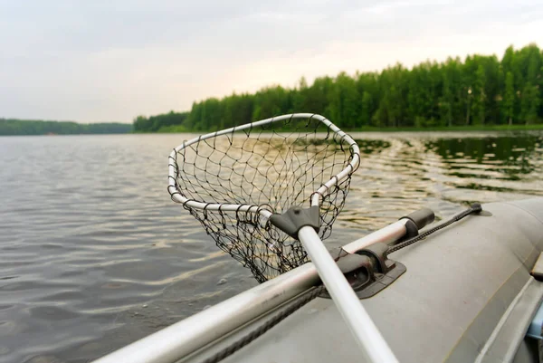 Pescar en un barco inflable. Una pala y una red de aterrizaje a bordo. Vista desde el Kayak hasta el hermoso lago —  Fotos de Stock