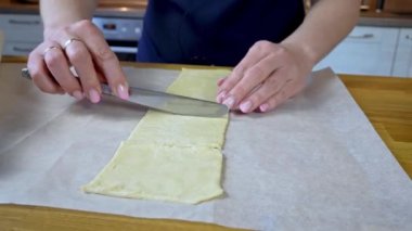 Pişiren eller hamuru bir bıçakla küçük parçalara ayırdı. Yemek pişirme süreci