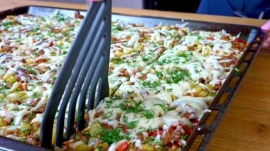 Şef, aile yemeği için fırında pişirilmiş bir tabak keser..