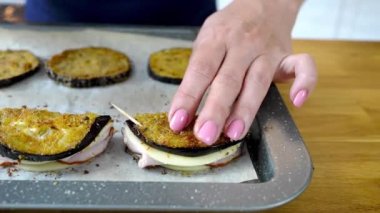 Şef, jambonlu ve peynirli patlıcan aperatifi yapar..