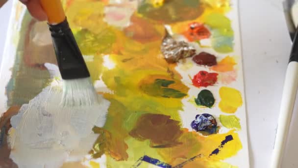 Ressam resim yapmak için farklı renkleri boya fırçasıyla karıştırır.. — Stok video
