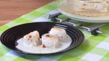 Şef siyah tabakta soslu istiridye servis ediyor. Ev yapımı deniz ürünleri..