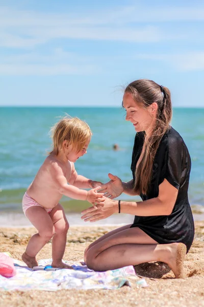 Petite fille bébé avec mère sur la plage — Photo