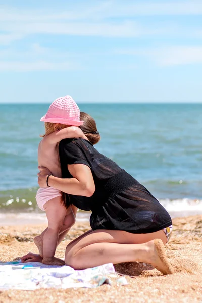 Petite fille bébé avec mère sur la plage — Photo