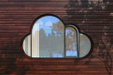 Evening facade of a modern building with window like a cloud