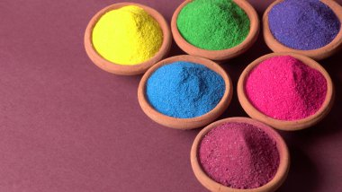 Diwali Festivali kaselerde rengarenk rangoli, arka planda kil lamba veya diya gösteriyor.