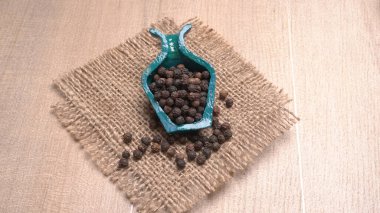 View of spices in the color bowl on white background with sackcloth, allspice