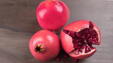 View of ripe pomegranates and pomegranate seeds on the table