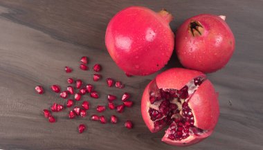 View of ripe pomegranates and pomegranate seeds on the table