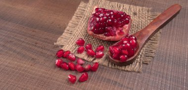 View of ripe pomegranates  and pomegranate seeds on the table with sackcloth