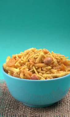 Çuval bez ve mavi arka planda bir kase karışık gevrek atıştırmalık