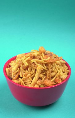 Mavi arka planda bir kase karışık çıtır atıştırmalık.