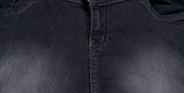 Beyaz arkaplanda fotokopi alanı olan siyah kot yığınının yakın plan görüntüsü 