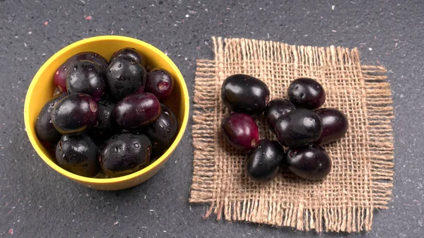 Jambul ya da Jamun (Syzygium cumini) desenli arka planda izole edilmiş kasede.