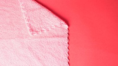 Kırmızı arkaplanda pembe peçete, yakın plan. 