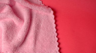 Kırmızı arkaplanda pembe peçete, yakın plan. 