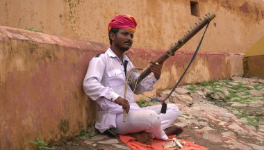 JAIPUR, INDIA - 11. AUGust, 2019: Rajasthani sokak müzisyeni geleneksel elbisesiyle Amer Kalesi 'nde sarangi müzik aleti çalıyor..