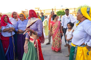 JAIPUR, INDIA 11 AĞUSTOS 2019: Geleneksel elbiseli kimliği belirsiz turist kadın ziyaretçiler grubu. Amber Fort avlusunda dans etmek ve eğlenmek Hindistan 'ın en önemli turistik yerlerinden biridir.