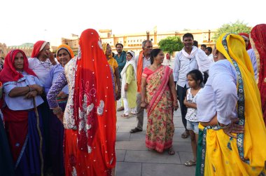 JAIPUR, INDIA 11 AĞUSTOS 2019: Geleneksel elbiseli kimliği belirsiz turist kadın ziyaretçiler grubu. Amber Fort avlusunda dans etmek ve eğlenmek Hindistan 'ın en önemli turistik yerlerinden biridir.