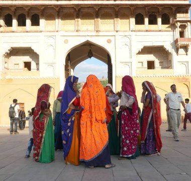 JAIPUR, INDIA 11 AĞUSTOS 2019: Geleneksel elbiseli kimliği belirsiz turist kadın ziyaretçiler grubu. Amber Fort avlusunda dans etmek ve eğlenmek Hindistan 'ın en önemli turistik yerlerinden biridir.