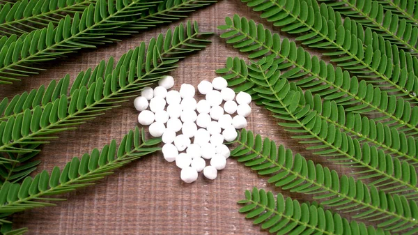 Closeup image of homeopathic medicine consisting of the pills and a bottle containing a liquid homeopathic substance.