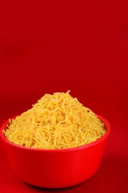 Hint baharatlı çerezi besan sev, diwali yemeği kırmızı arka planda.