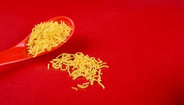 Hint baharatlı çerezi besan sev, diwali yemeği kırmızı arka planda.