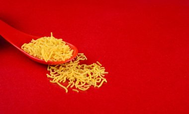 Hint baharatlı çerezi besan sev, diwali yemeği kırmızı arka planda.