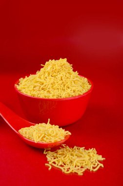 Hint baharatlı çerezi besan sev, diwali yemeği kırmızı arka planda.