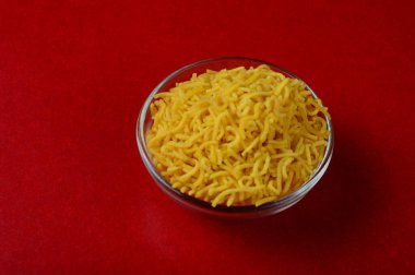 Hint baharatlı çerezi besan sev, diwali yemeği kırmızı arka planda.